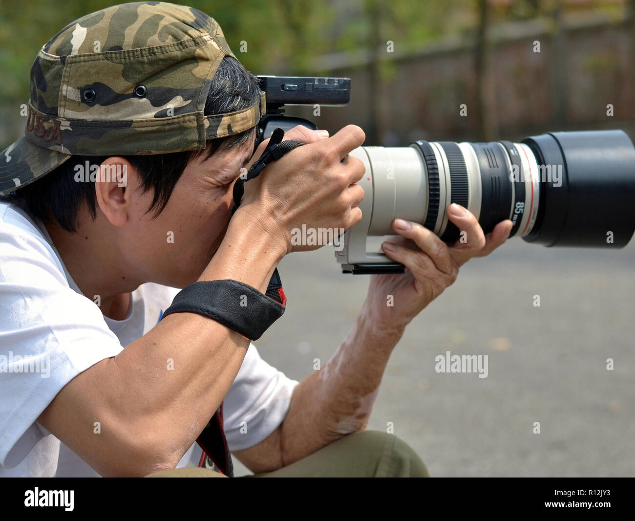Vietnamesische professioneller Fotograf macht ein Foto mit seiner Canon EOS 6D DSLR-Kamera. Stockfoto