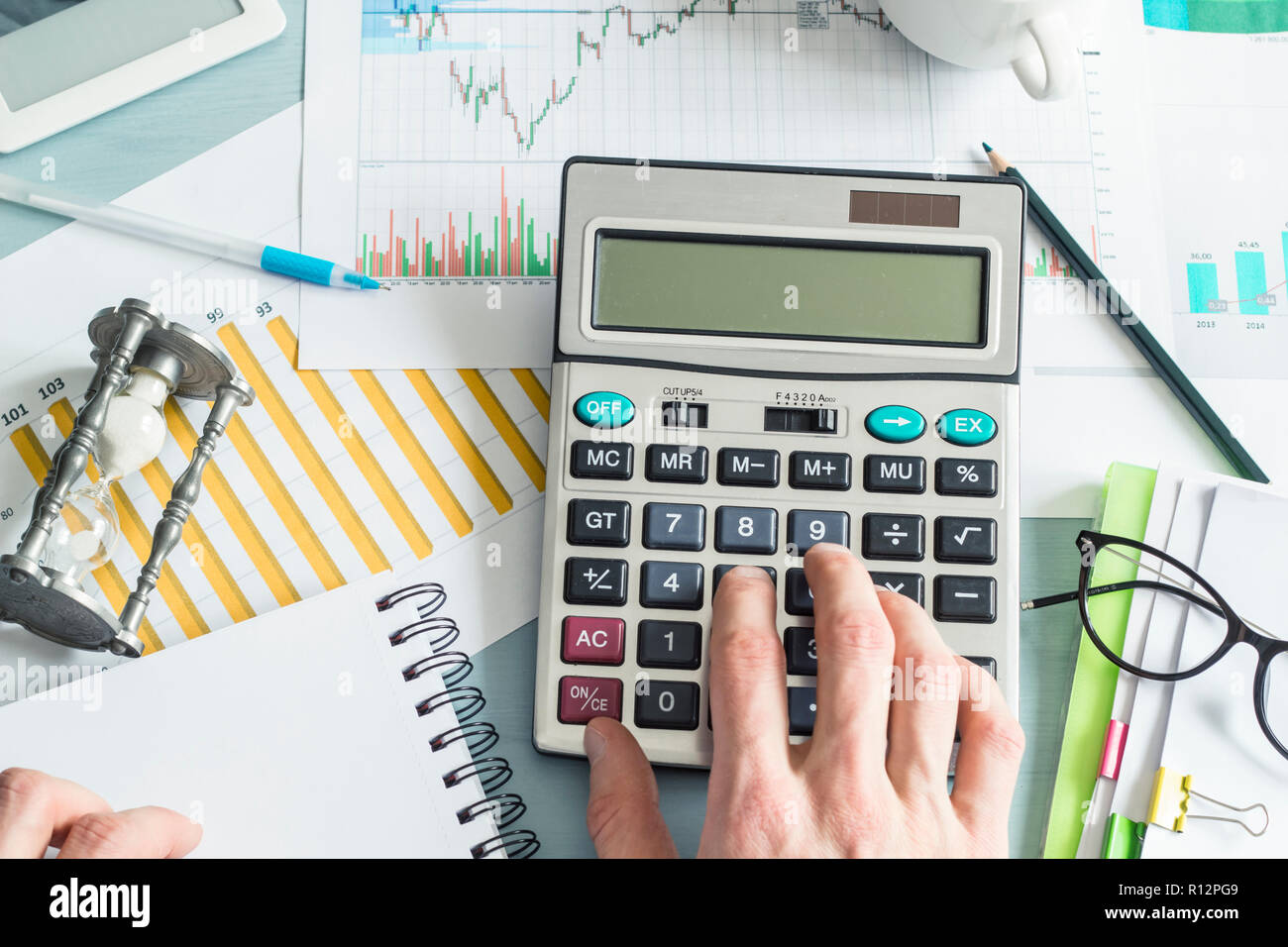 A business Person, ein Buchhalter, erstellt einen Finanzbericht mit einem Rechner während an einem Schreibtisch im Büro zu sitzen. Stockfoto