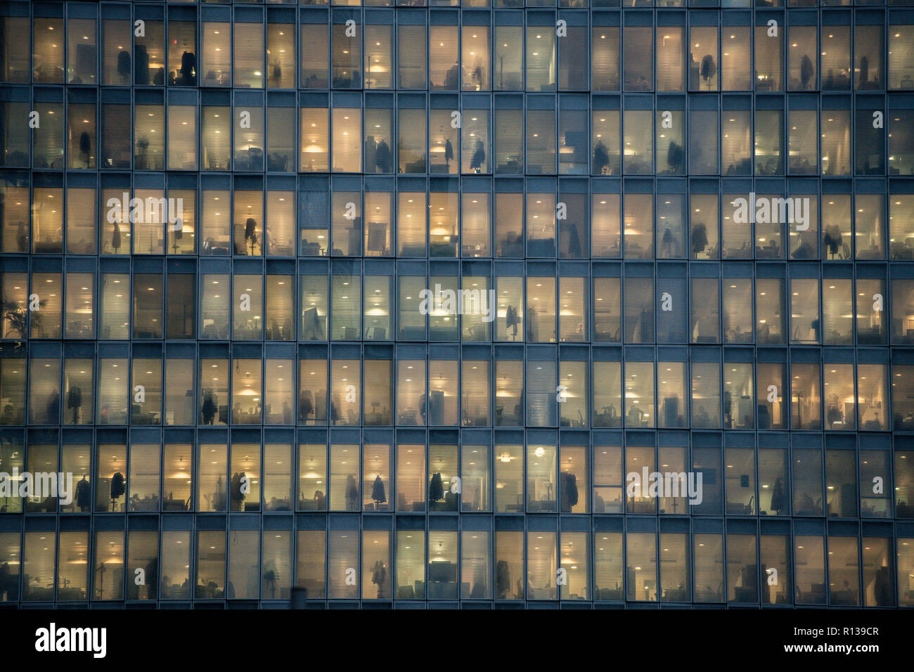Blick auf Fenster mit Menschen bei der Arbeit im Inneren eines Bürogebäudes in der Nacht in Mailand, Italien am 8. November 2018. Stockfoto