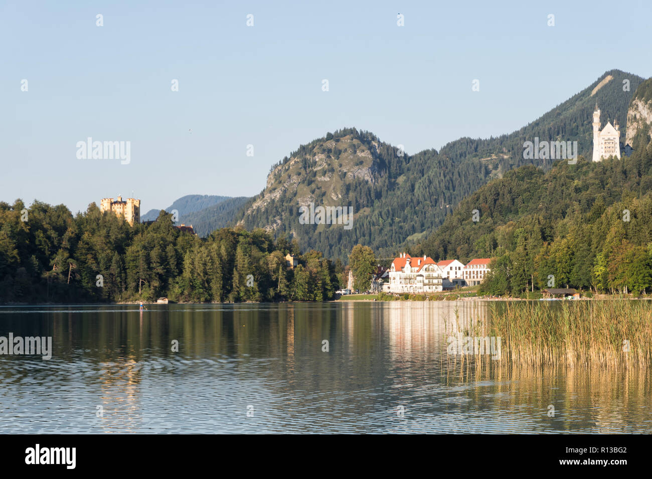 Alpsee mit Hohenschwangau, Neuschwanstein und Restaurant Alpenrose am See an einem warmen sonnigen Abend Ende September. Schwangau, Füssen, Bayern Stockfoto