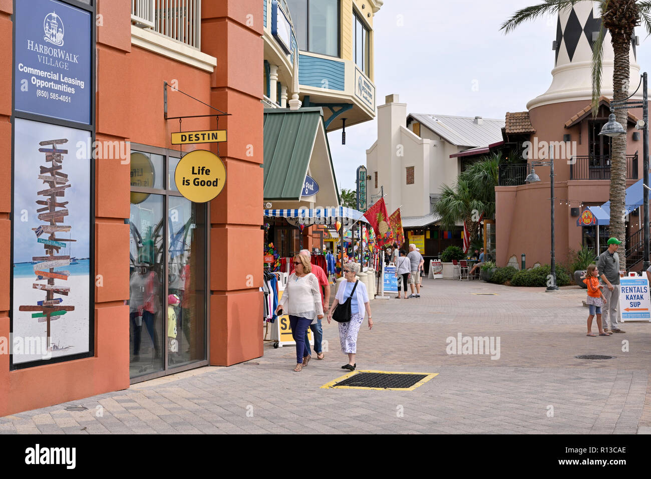 Reife und ältere Käufer vorbei gehen. speichert im Ferienort HarborWalk Village in Destin, Florida, USA. Stockfoto