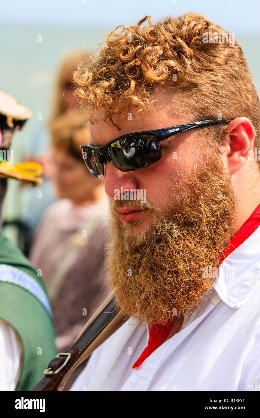 Broadstairs Folk Woche. Junger Mann, 20 Jahre, steht im Freien mit dunkler Sonnenbrille auf sehr buschig Ingwer farbige Bart und. Sehr ernsten Ausdruck. Stockfoto