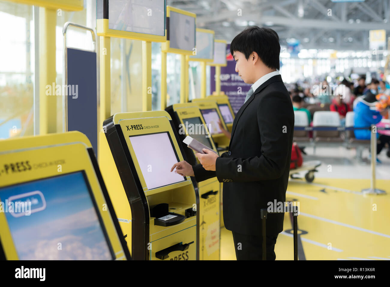 Business Travel - asiatische Geschäftsmann mit Self Check-in-Automaten am Flughafen. Technik im Flughafen. Stockfoto