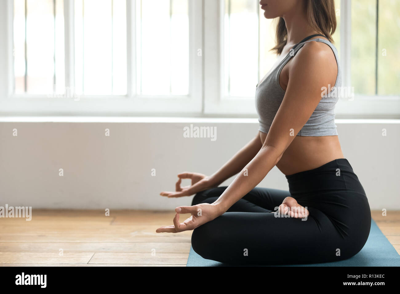 Junge sportliche Frau Üben Yoga, Ardha Padmasana Übung Stockfoto