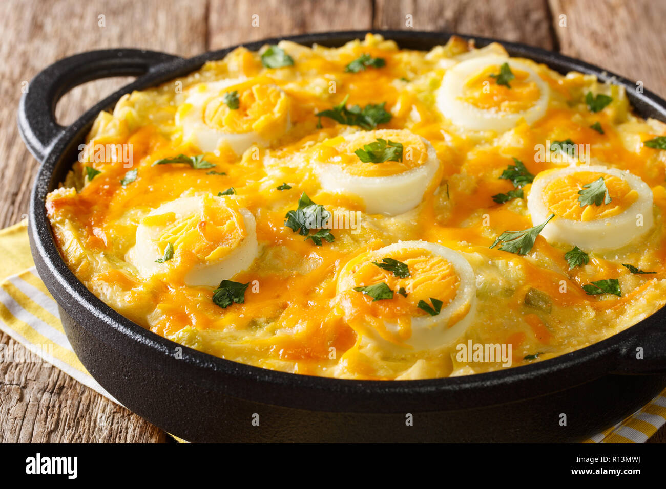 Authentische britische Essen. Anglesey Eier überbacken mit Kartoffelbrei, Lauch Käsesoße close-up auf dem Tisch. Horizontale Stockfoto