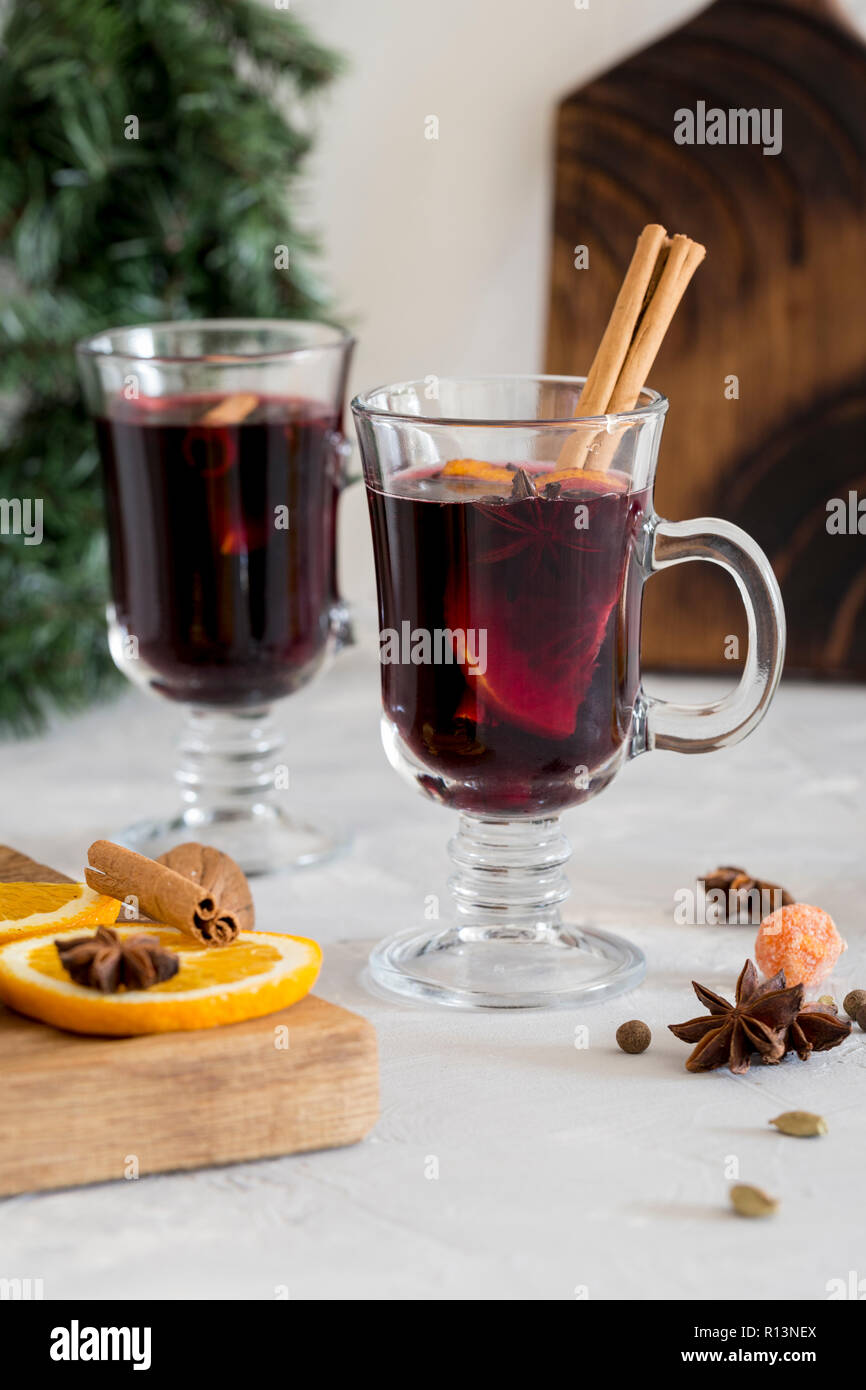 Winter Zusammensetzung. Glühwein im Glas auf weißen Hintergrund. Holz, tanne Kranz, Orange, Zimt und Gewürze in der Nähe. Stockfoto