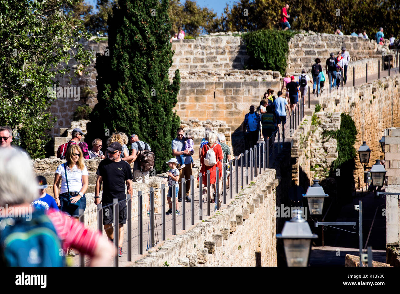 Menschen zu Fuß auf der Stadtmauer in der Altstadt von Alcudia, Mallorca Stockfoto