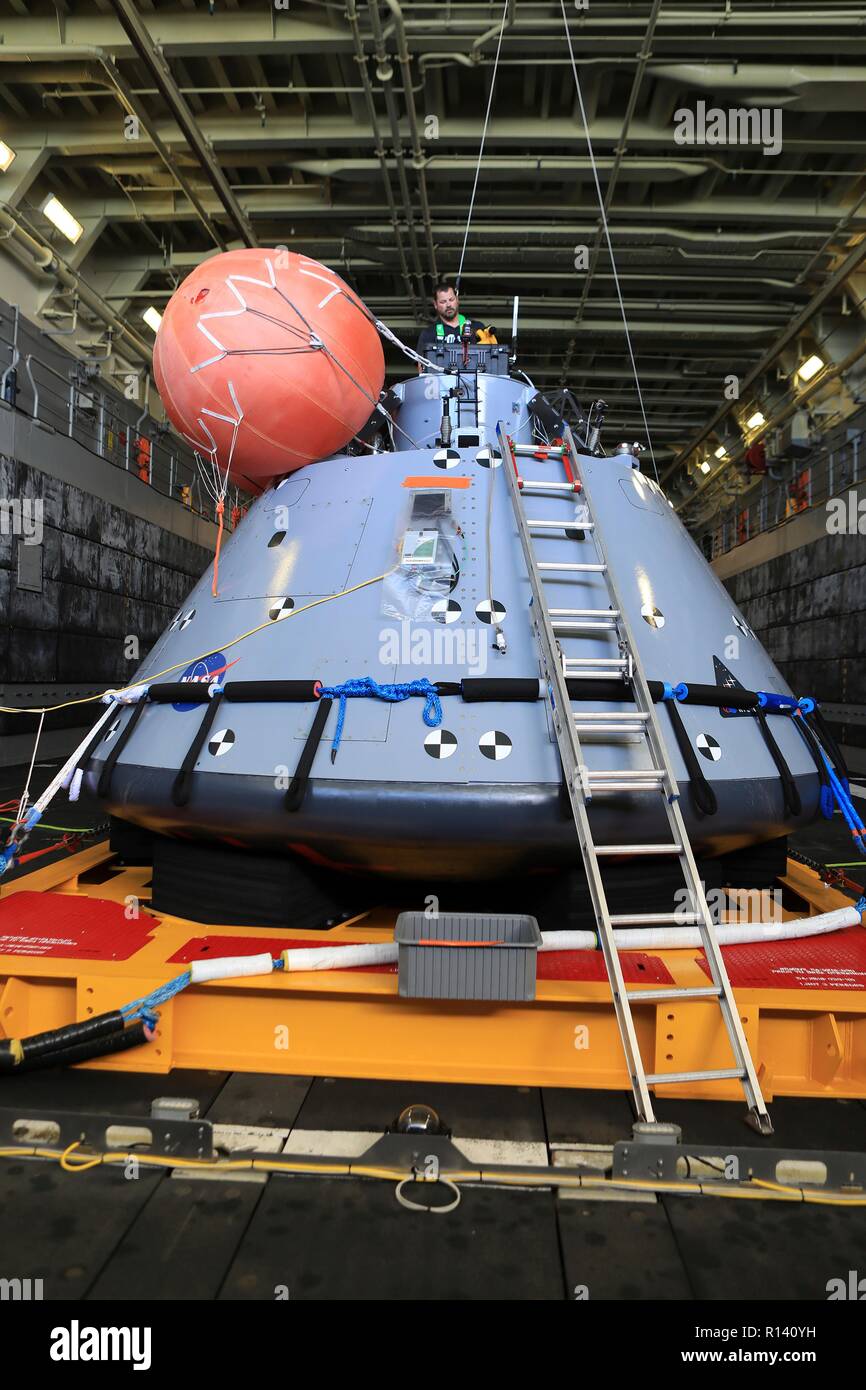 Das Team der NASA und der US-Marine Taucher bereiten die Orion Next Generation Space capsule für eine Nacht Erholung Test in der gut Deck der USS John S. Murtha November 3, 2018 im Pazifischen Ozean. Die NASA und die US-Marine hat nicht ausgeführt, offenen Ozean der Wiederherstellung eines bemannten Raumkapsel seit der Apollo Projekt in den 60er Jahren und sind den Prüfverfahren und -Hardware, der verwendet werden soll, um das Raumfahrzeug Orion wiederherzustellen, nachdem es den in den Pazifischen Ozean Spritzer folgende künftige interplanetare Raumfahrt Missionen. Stockfoto