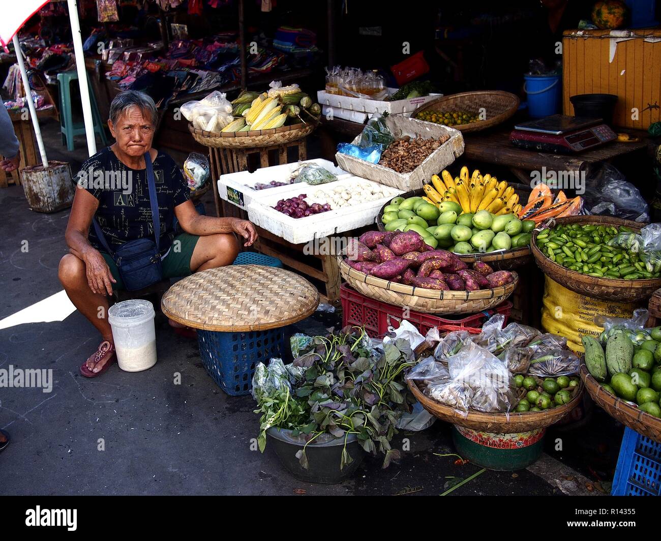 BINANGONAN, Rizal, Philippinen - 8. NOVEMBER 2018: eine Obst- und Gemüse Anbieter verkauft frische Produkte auf einem öffentlichen Markt. Stockfoto