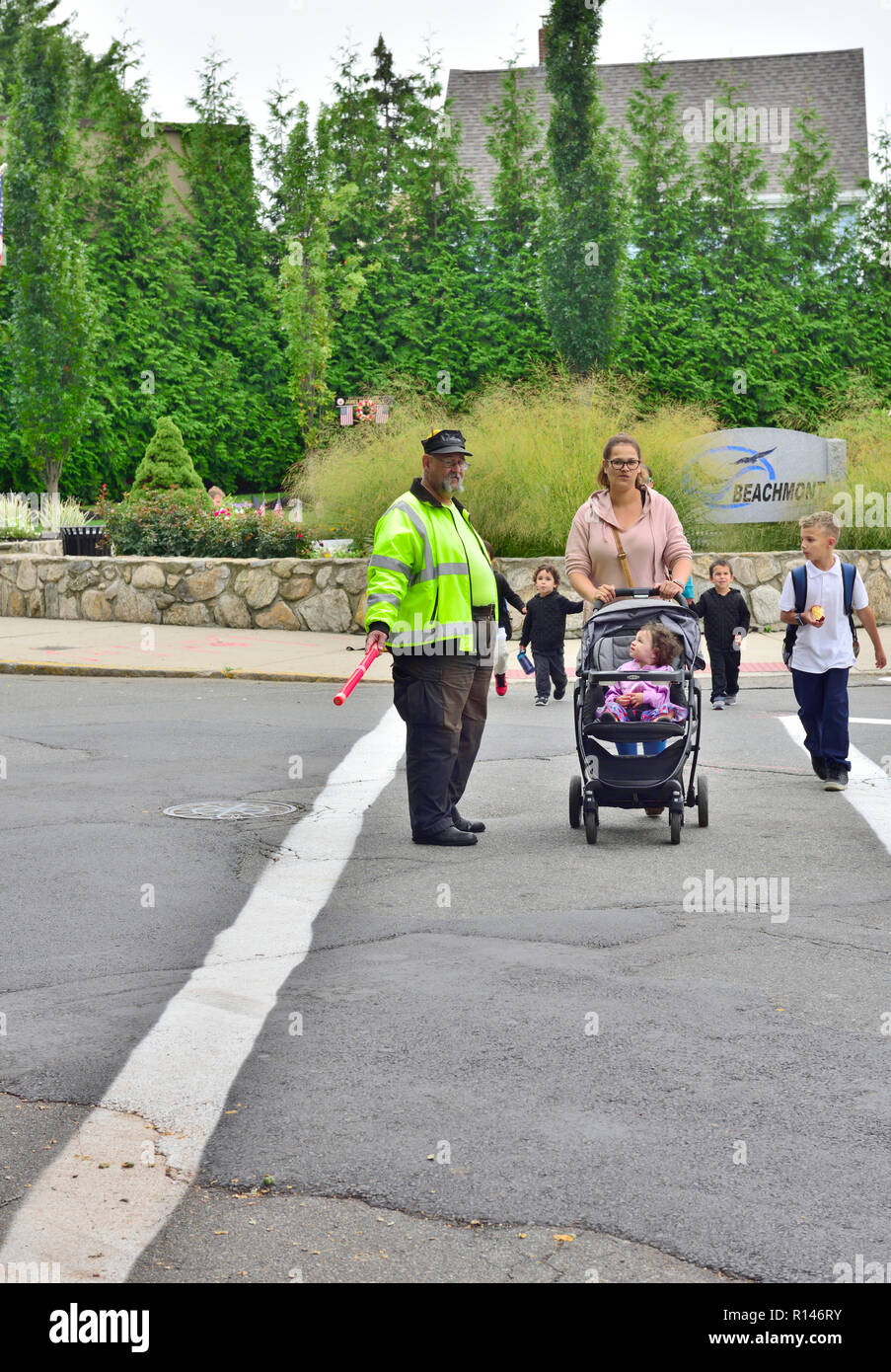 Schule Kreuzweg guard helfen Mutter und Kindern auf der anderen Straßenseite, Vorort von Boston, Massachusetts, USA Stockfoto