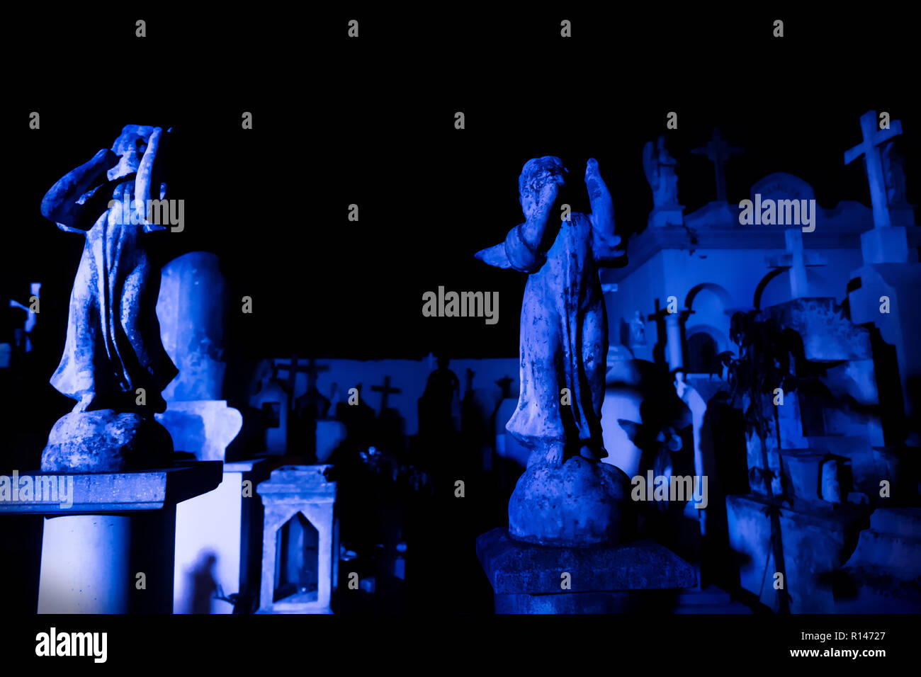 Zwei Engel Statuen an dunklen Blau beleuchtet Grabsteine während der Dämmerung in Cementerio General in Merida, Mexiko Stockfoto