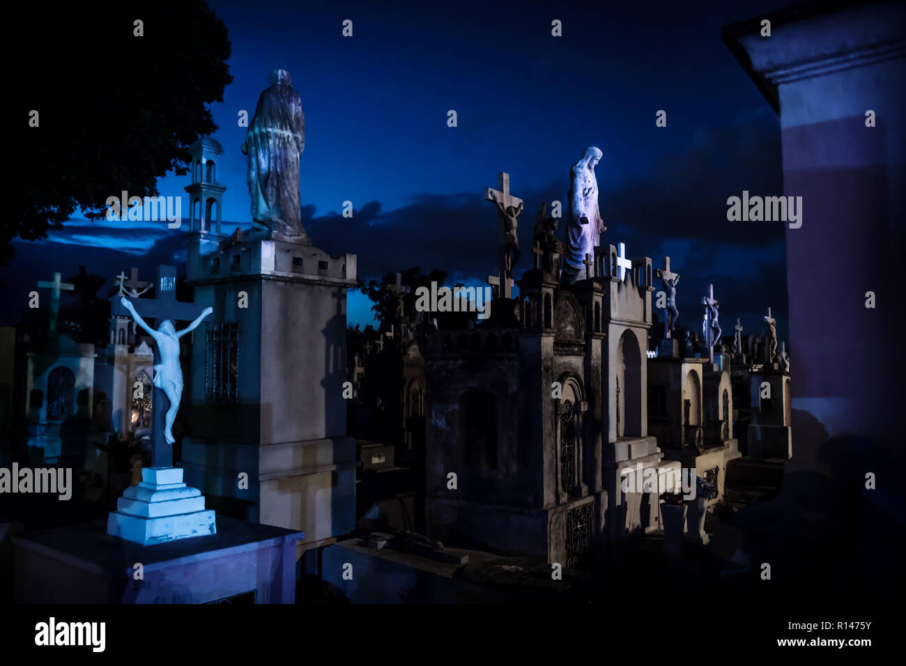 Jejus Statuen an dunklen Blau beleuchtet Grabsteine während der Dämmerung in Cementerio General in Merida, Mexiko Stockfoto