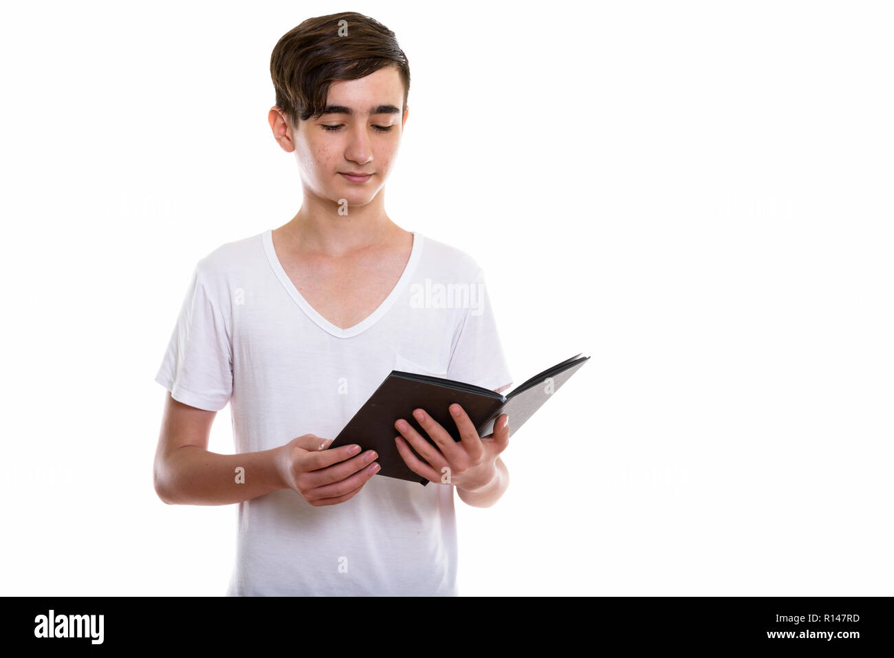 Studio shot der jungen schönen persischen Teenager lesen Buch Stockfoto