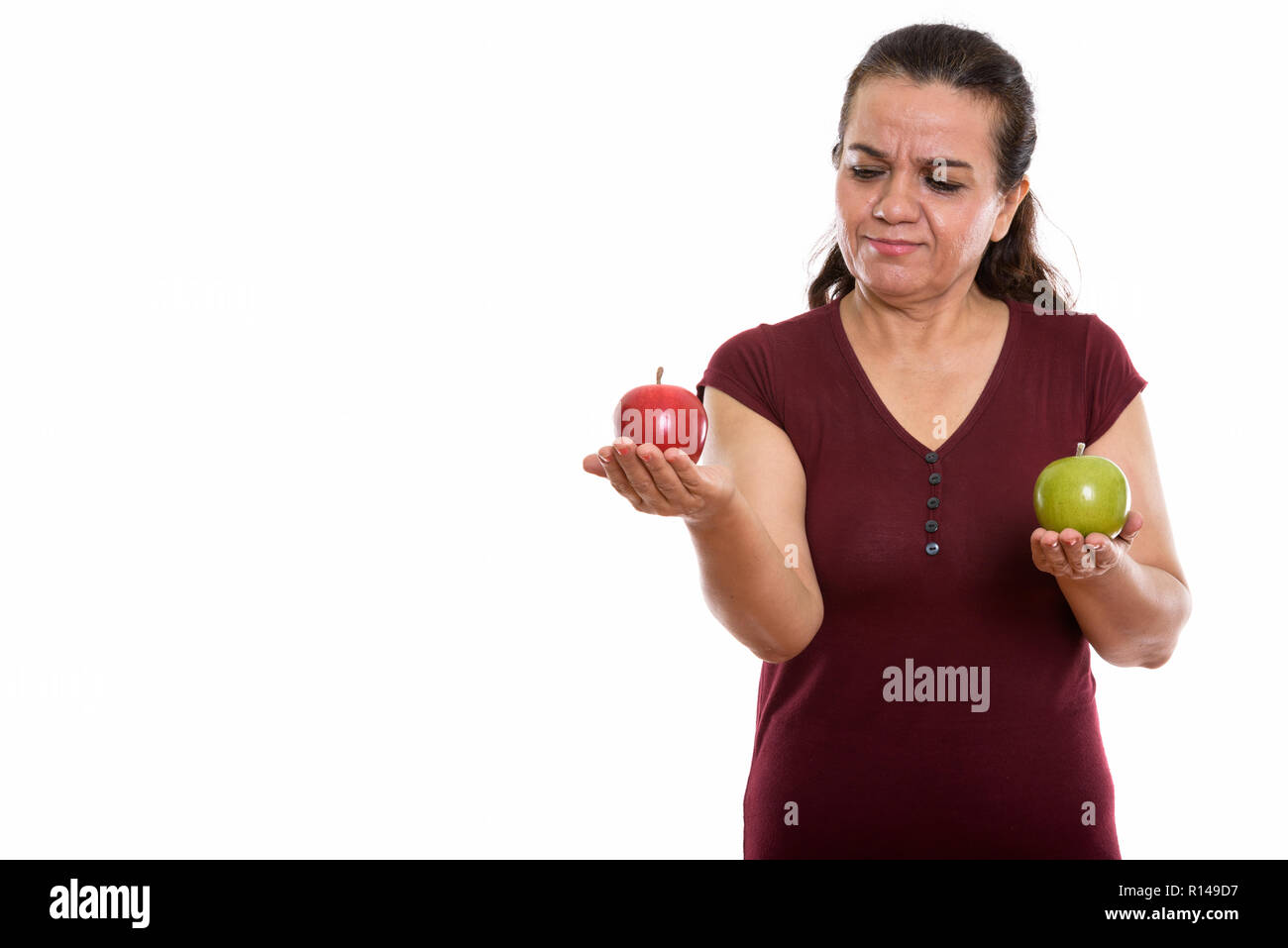 Studio shot reifer persische Frau an der rote Apfel, während h Stockfoto