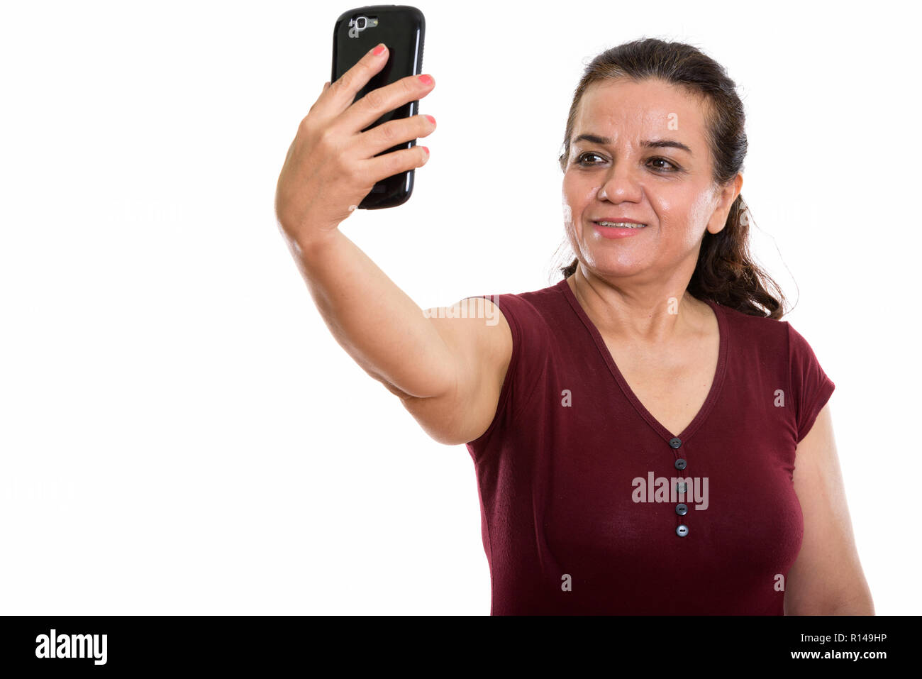 Studio shot von Happy reife persische Frau lächelnd, während s unter Stockfoto