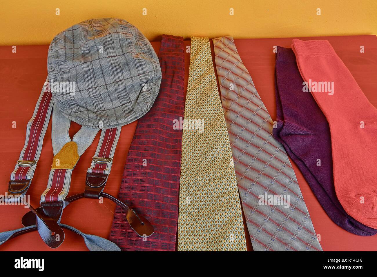 Man Kleidungsstücke. Kleidung Konzept für Männer. Farbenfrohe Socken, Krawatten, Klammern und geprüft, flacher Deckel auf Claret Hintergrund. Klassische Konzept der Männer Kleider. Close-up Stockfoto