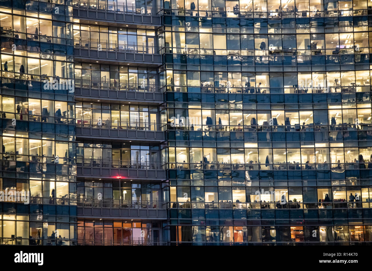 Blick auf Fenster mit Menschen bei der Arbeit im Inneren eines Bürogebäudes in der Nacht in Mailand, Italien am 8. November 2018. Stockfoto