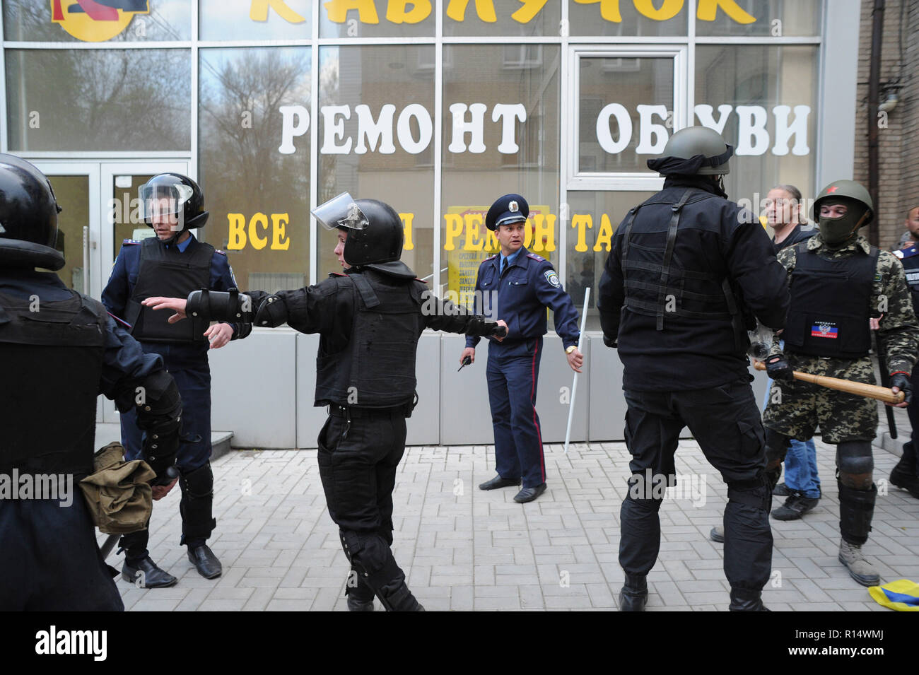 April 28, 2014 - Donezk, Ukraine: Ukrainische Bereitschaftspolizei bewegen sich in einer friedlichen Demonstration der Ukrainer für die Einheit ihres Landes zu schützen. Trotz Polizeischutz, einer Gruppe von pro-russischen Separatisten heftig angegriffen und verteilte die friedlichen Demonstranten. Die pro-russische separatistische Gruppe, meist Jugendliche in Balaclava, dann ihre Aktionen gefeiert durch schreien Sie hatten zertrümmerte 'Faschisten'. Une Manifestation pacifique en faveur de l'unite de l'Ukraine Donetsk est brutalement dispersee Gleichheit des Gruppen separatistes pro-Russes armes de Schlagstöcke et, pour Schneckaufkommen, d'armes Blanc Stockfoto
