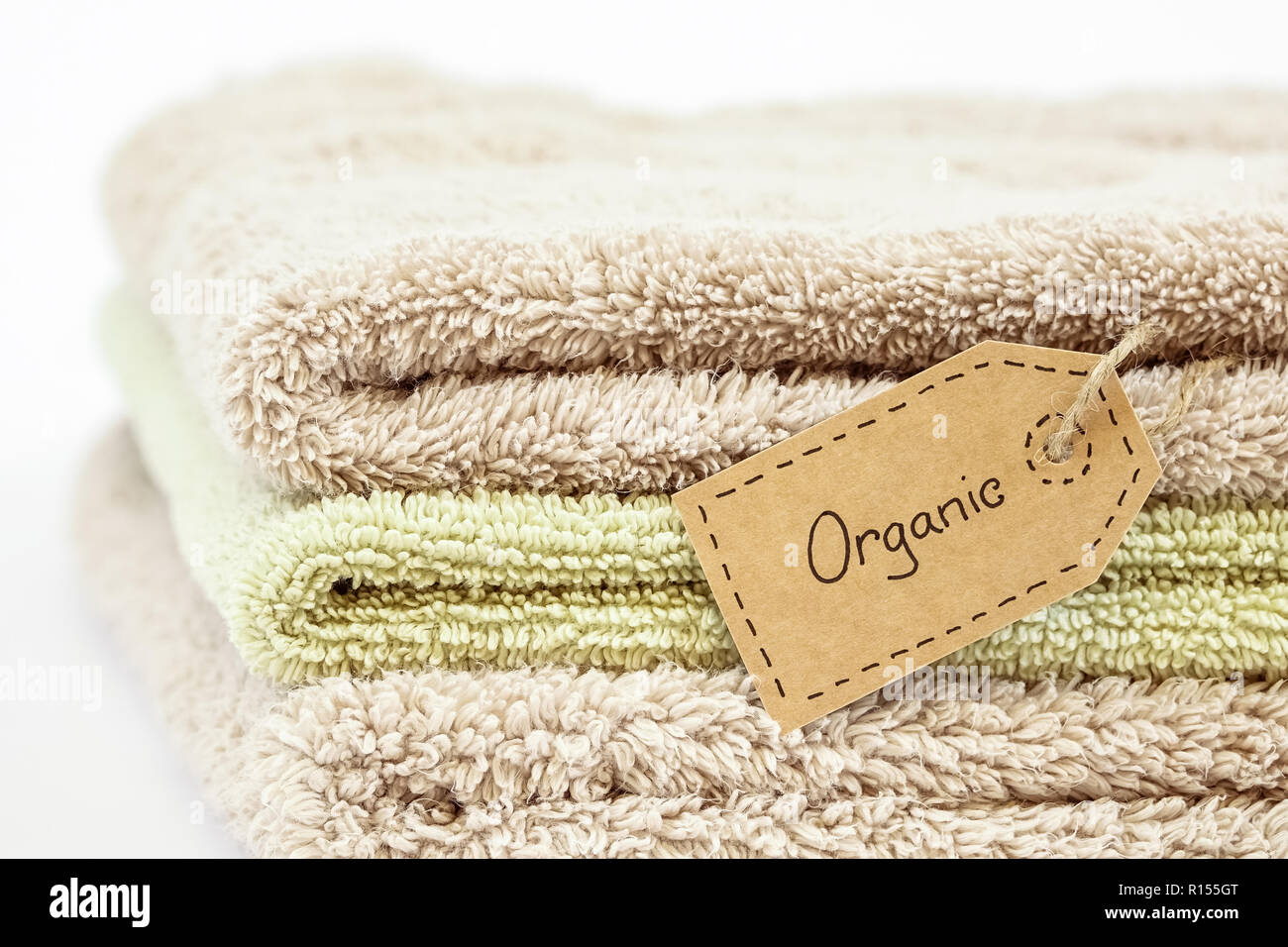 Stapel aus organischer Baumwolle Handtücher auf weißem Hintergrund. Eco Textile Tag. Stockfoto