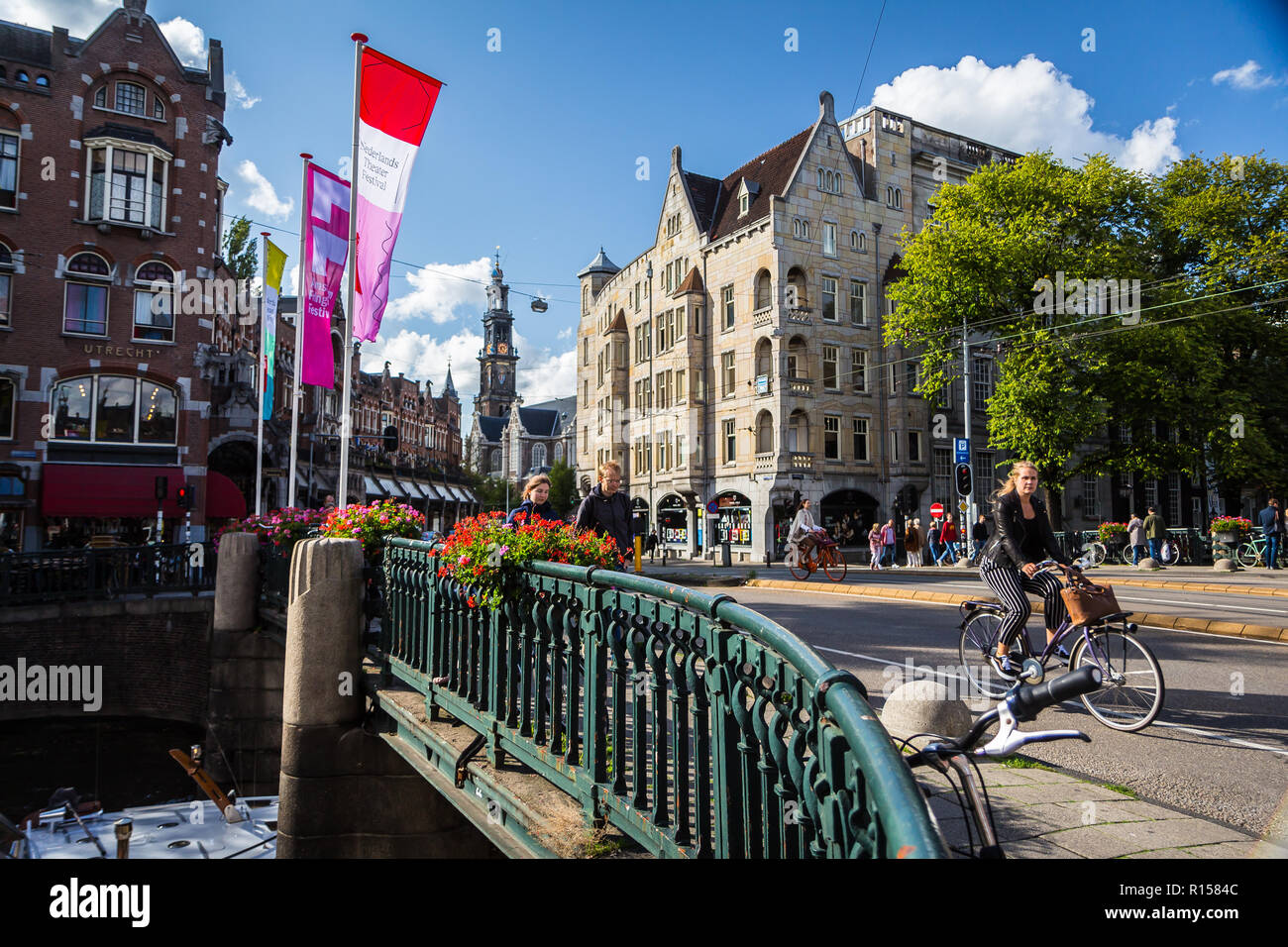 AMSTERDAM, Niederlande - 7 September, 2018: die Frau mit dem Fahrrad auf der Brücke über dem Wasser Kanal in Amsterdam, alte Stadt Stockfoto