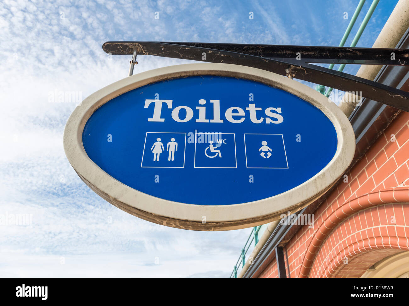 Hängende öffentliche Toiletten Schild für Männer, Frauen und Behinderte, in Großbritannien. Britische Öffentlichkeit Loos. Öffentliche Toiletten. Stockfoto