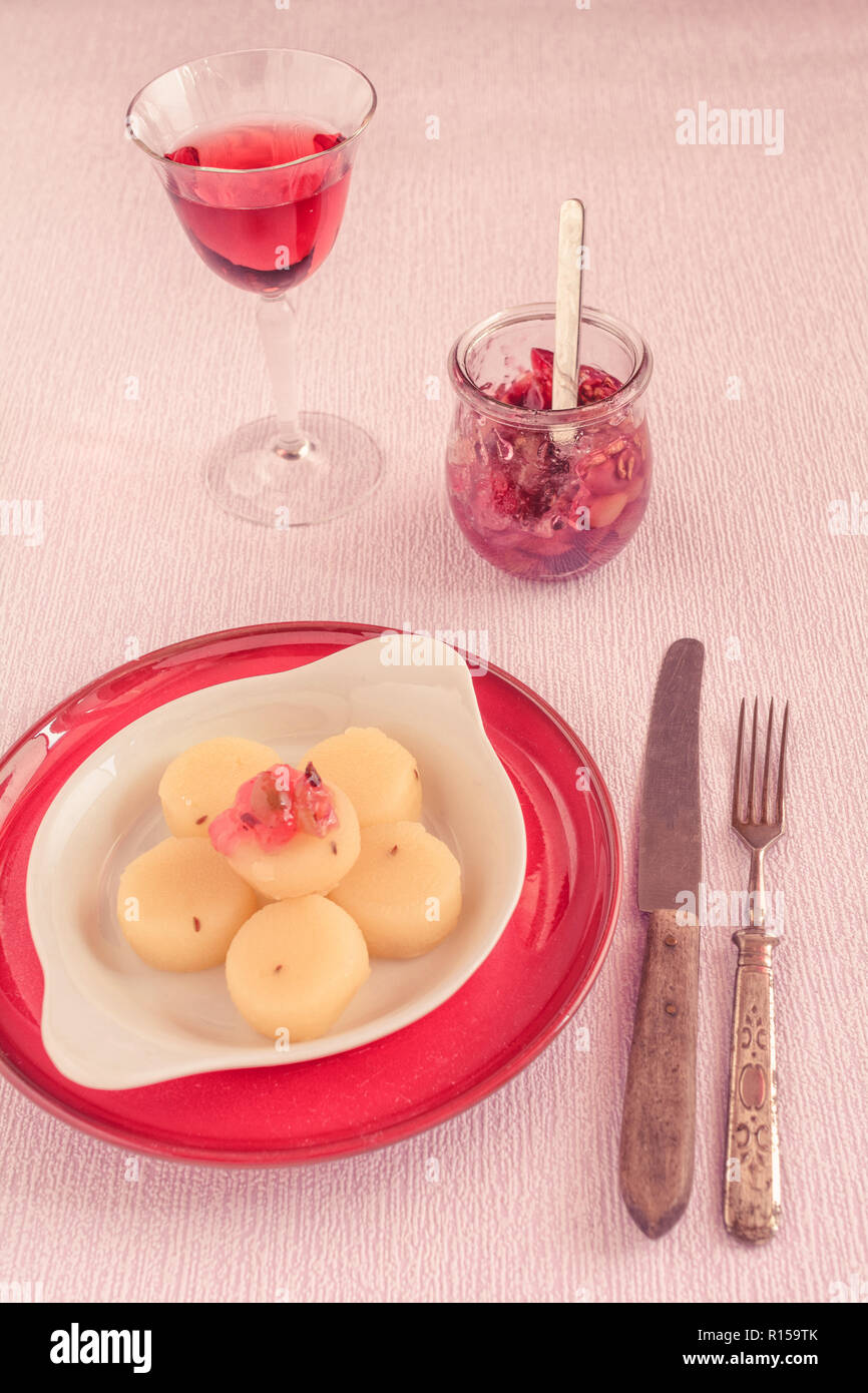 Harzer Käse auf eine Porzellanschale mit einem Glas Wein und einem Glas Kompott mit Trauben Stockfoto