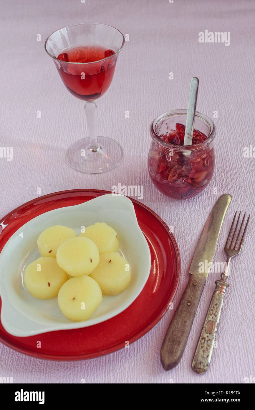 Harzer Käse auf eine Porzellanschale mit einem Glas Wein und einem Glas Kompott mit Trauben Stockfoto