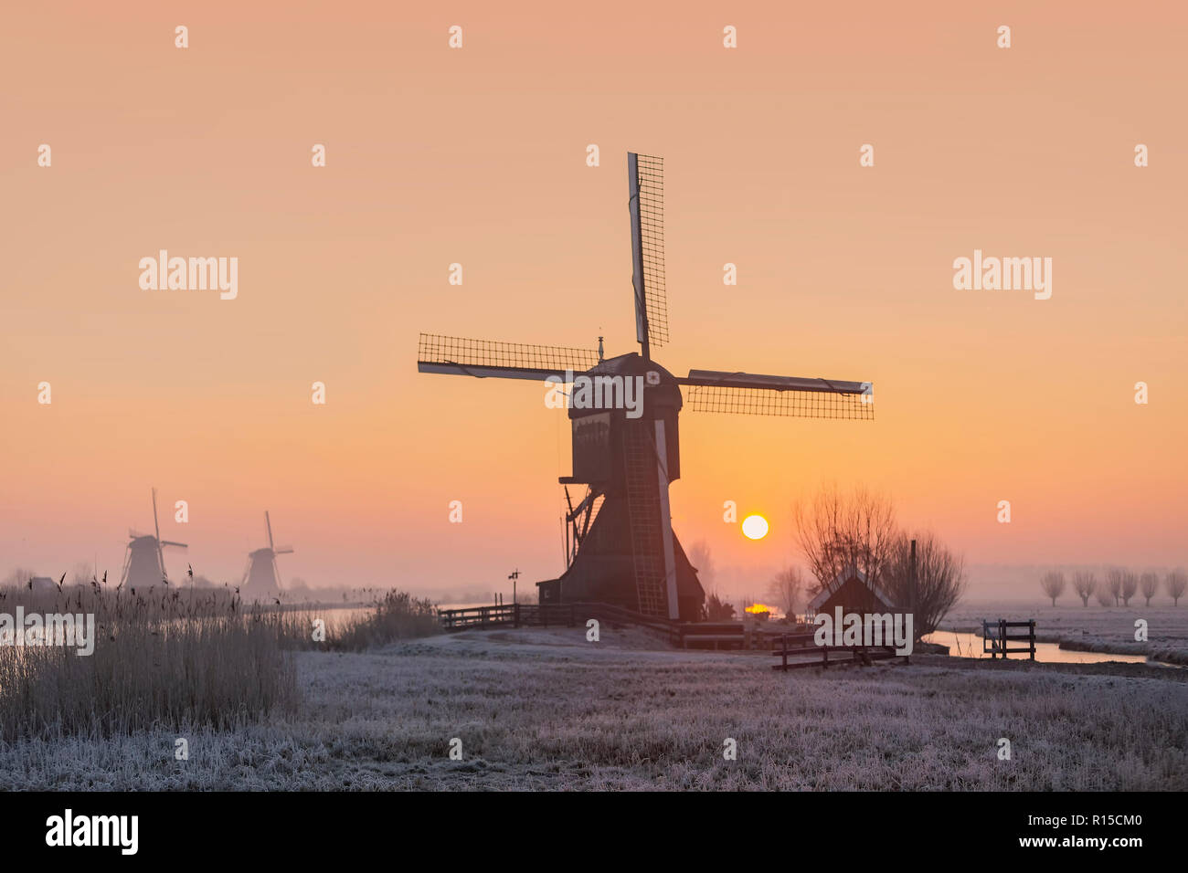 Typische alte niederländische sunset Landschaft im ländlichen Raum der Niederlande mit Mühle und niedrige Wolken Stockfoto