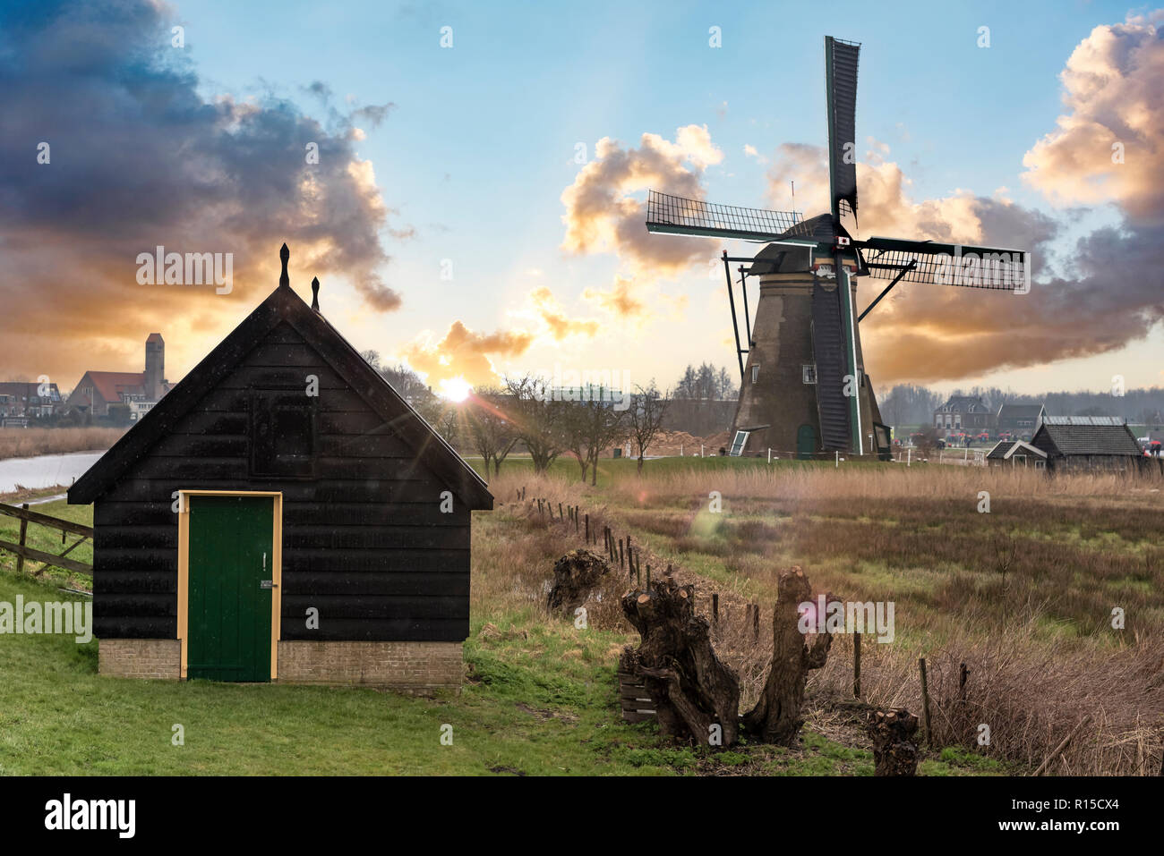 Typische alte niederländische sunset Landschaft im ländlichen Raum der Niederlande mit Mühle und niedrige Wolken Stockfoto