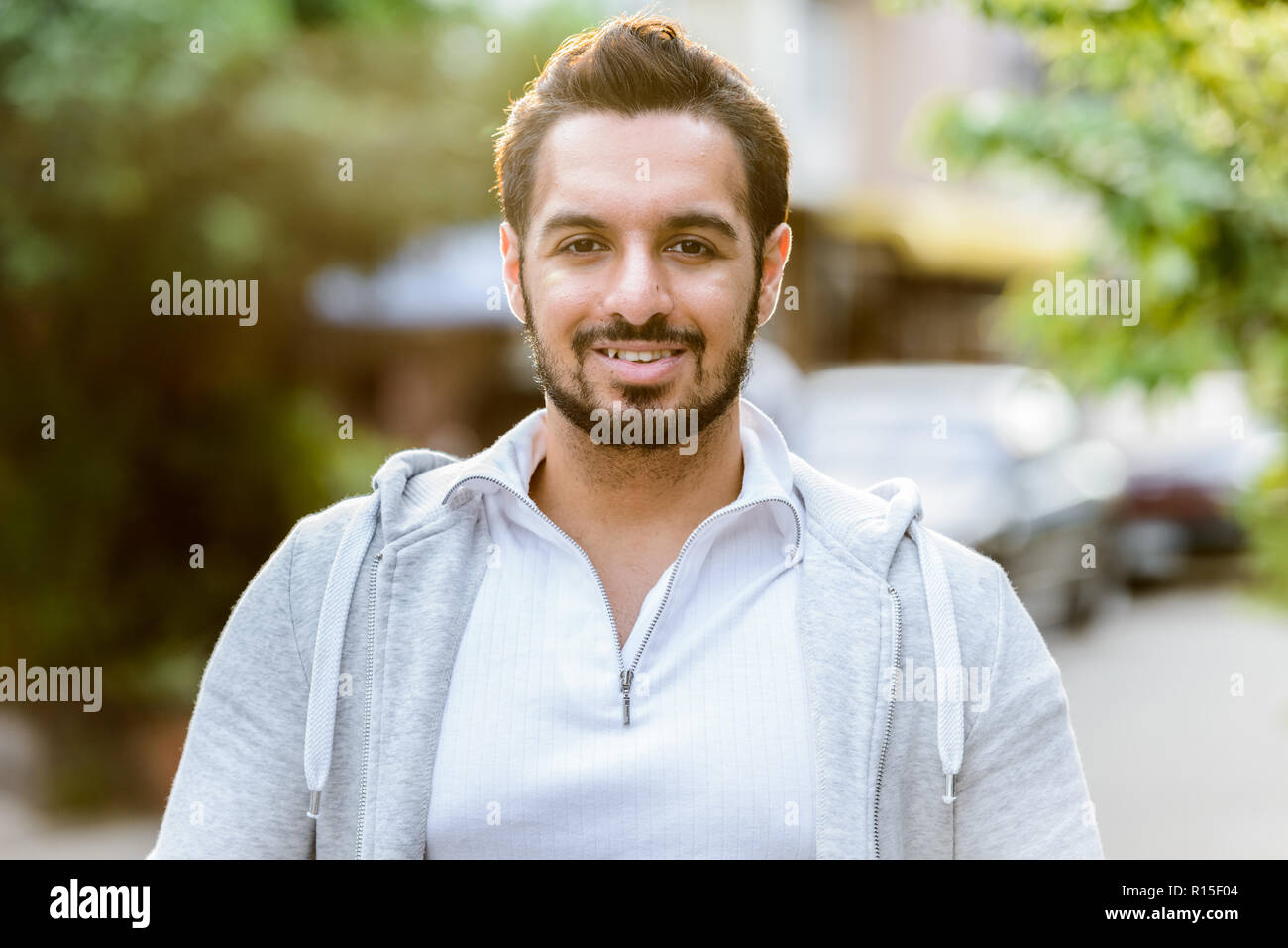 Porträt der jungen indischen Mann glücklich lächelnd im Freien Stockfoto