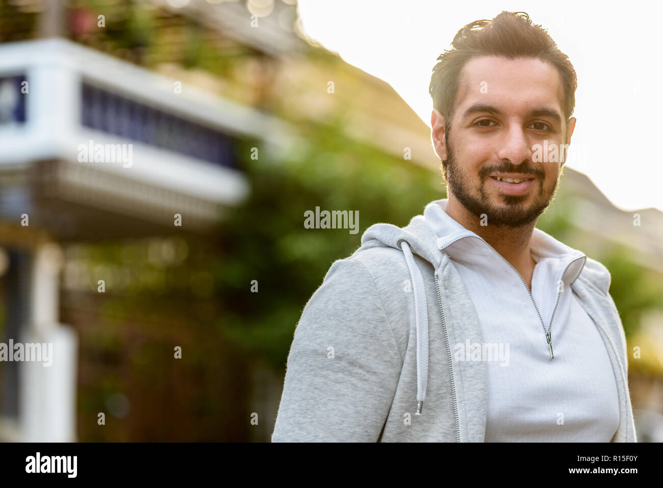 Porträt der jungen indischen Mann glücklich lächelnd im Freien Stockfoto