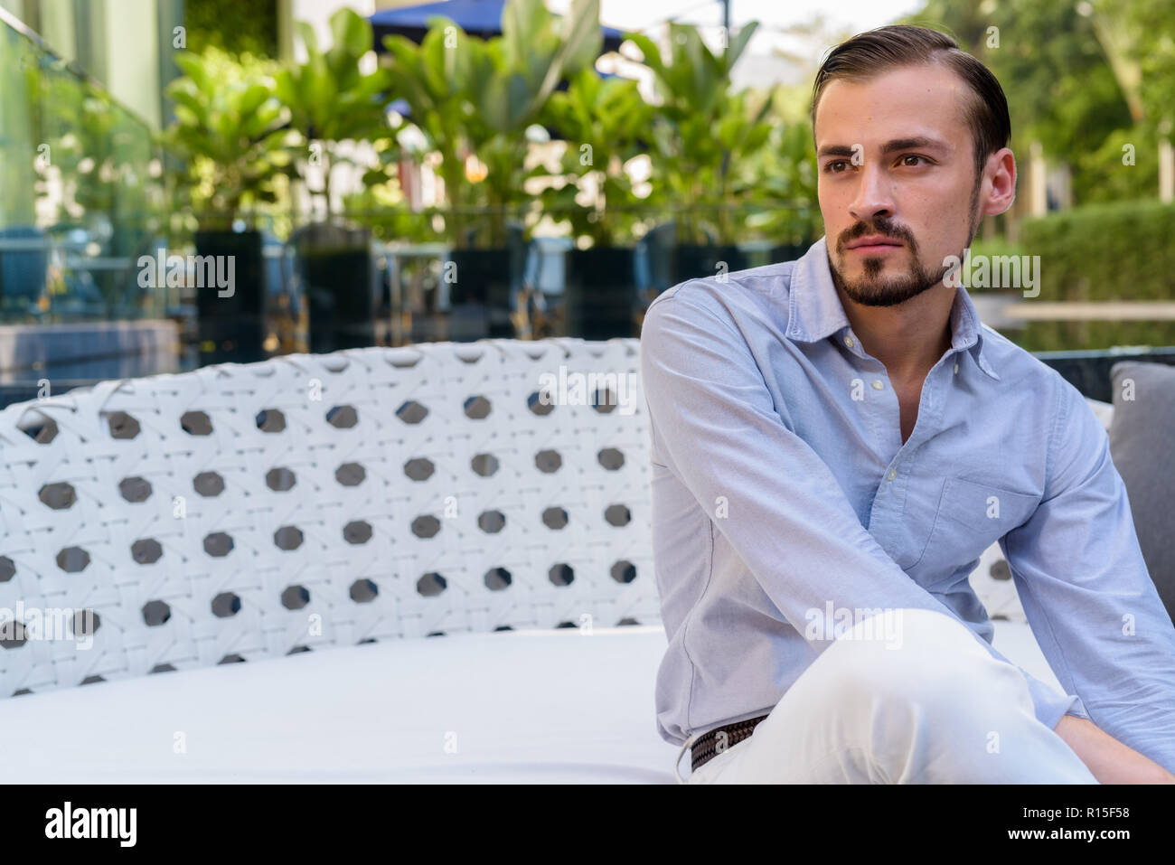 Portrait der junge Bartgeier modische Mann sitzt im Freien Stockfoto