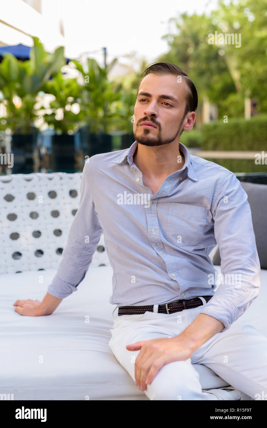 Portrait der junge Bartgeier modische Mann sitzt im Freien Stockfoto