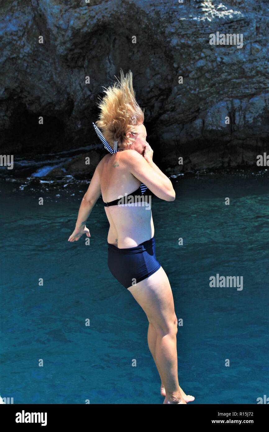 Kaukasische weiblichen Tourist springt / Tauchgänge vom Boot ins Wasser in Dalyan, Türkei. Stockfoto