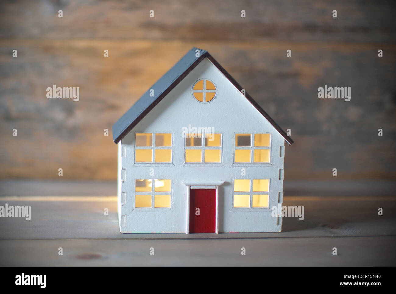 Modell Haus mit Lichtern auf der Innenseite über einen hölzernen Hintergrund Stockfoto