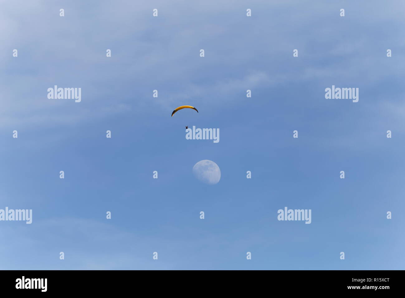 Gleitschirm fliegen direkt über dem Mond am Himmel über dem See von Annecy Frankreich Stockfoto