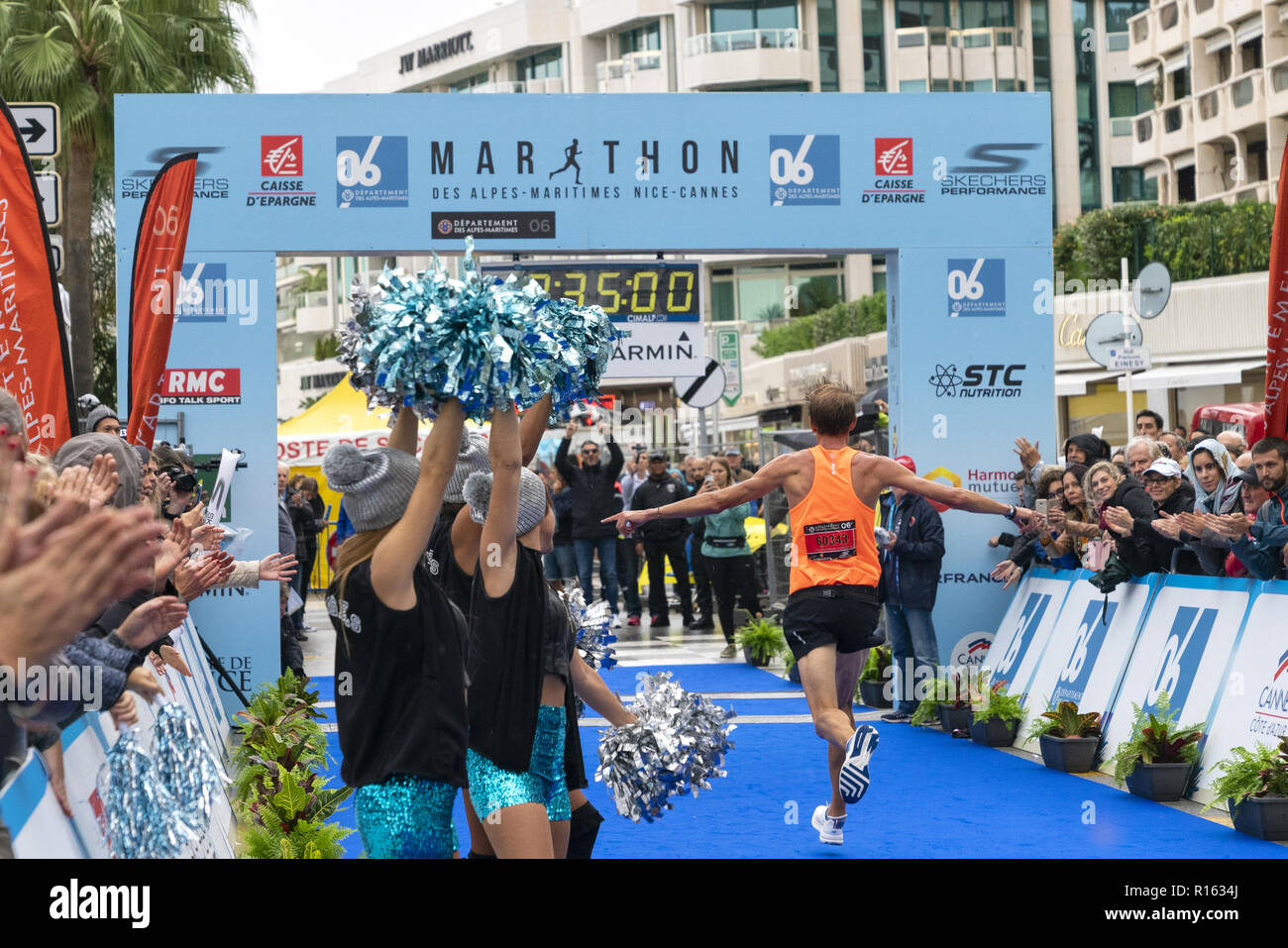 4 Nov 2018 - Cannes, Frankreich. Eine athletische Runner abgeschlossen ist 42 km von Nizza und endet in Cannes. Die Zuschauer feuern die Läufer. Stockfoto