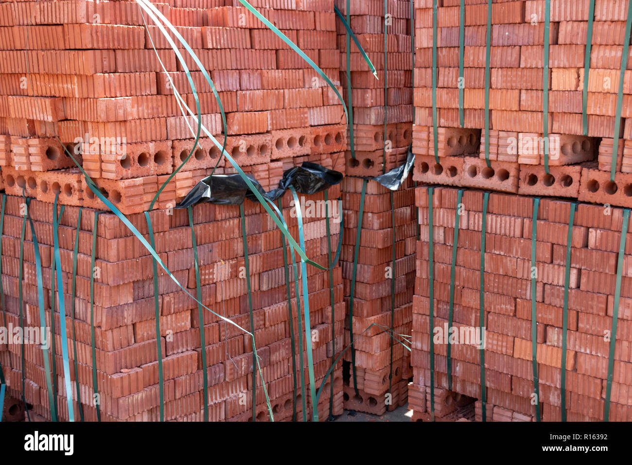 Eine Nahaufnahme von roten Ziegeln geschält und in harter Kunststoff Klebeband, mit dem das einzelne Steine verhindert ein Verrutschen oder Herabfallen der Stapel gewickelt Stockfoto