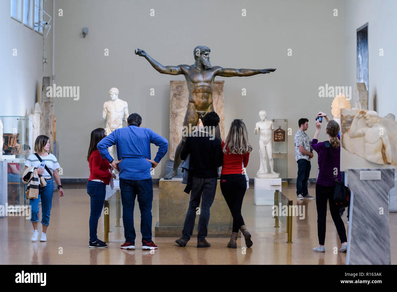 Athen. Griechenland. Besucher im Archäologischen Nationalmuseum von Athen im Artemision Bronze, Statue, Poseidon und Zeus, ancie Stockfoto