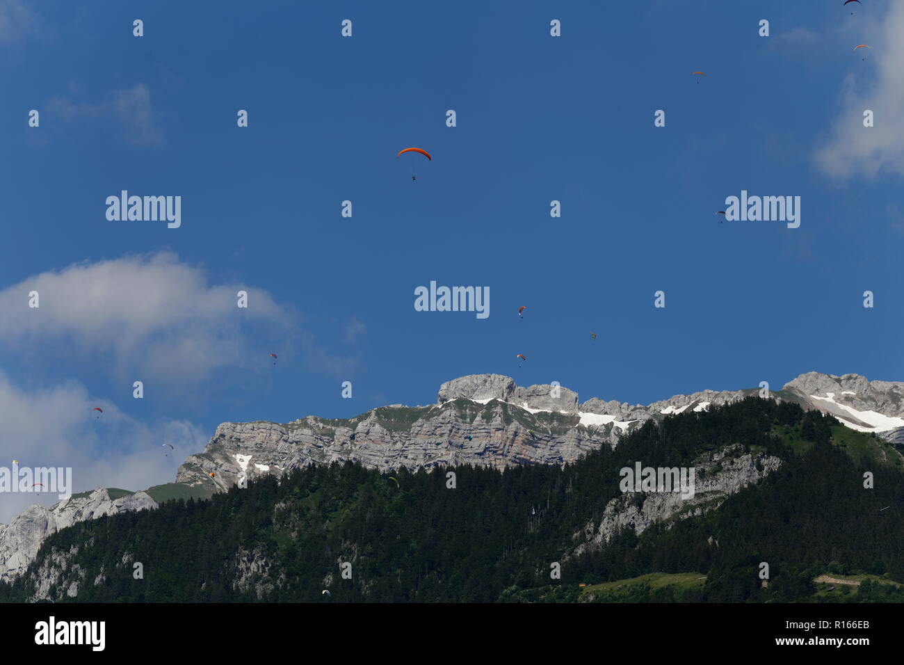Red Gleitschirm- und Gleitschirme fliegen hoch über La Tournette über den See von Annecy Frankreich Stockfoto