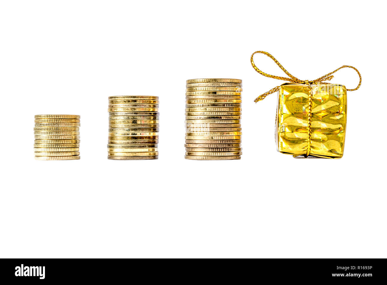 Geschenkbox in Gold Verpackung verband mit einem Bogen neben Münzen Spalte  close-up auf weißem Hintergrund Stockfotografie - Alamy