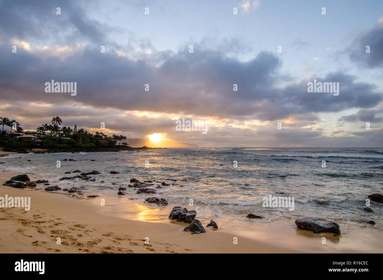 Wellen über kleine Coral Felsen an Chun's Reef und Jocko's Cove auf der North Shore von Oahu in Hawaii im Sonnenuntergang Stockfoto