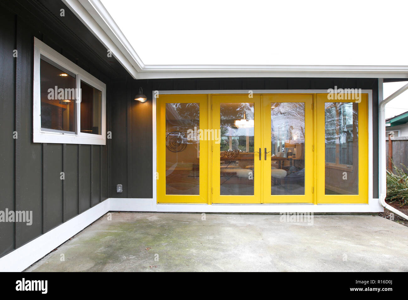 Home Exterieur mit gelben Terrassentüren, Ansicht vom Hof. Stockfoto