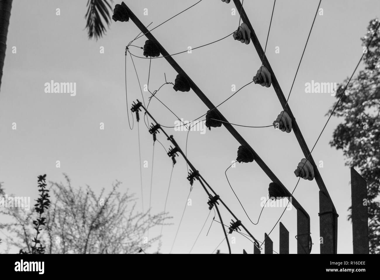 Aus der Nähe zu sehen. eine Alte kaputte elecrtic fechten in Schwarz und Weiß auf einem isolierten grauer Hintergrund Stockfoto