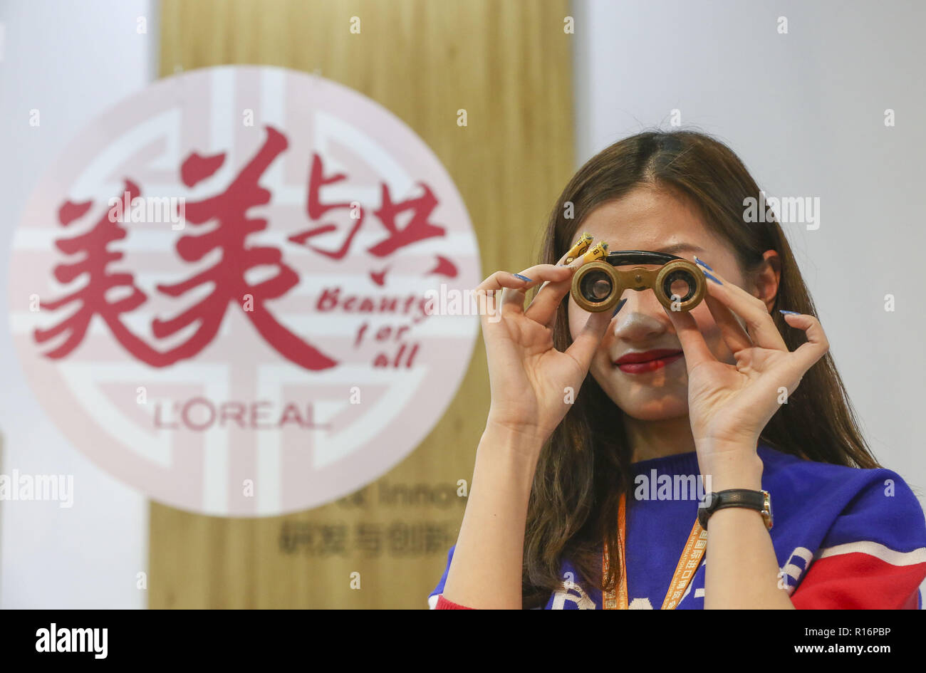 Shanghai, China. 9 Nov, 2018. Ein Aussteller von L'Oreal an der Bekleidung, Accessoires & Konsumgüter bereich der ersten China International Import Expo (CIIE) in Shanghai, China, November 9, 2018. Credit: Yin Schleifring/Xinhua/Alamy leben Nachrichten Stockfoto
