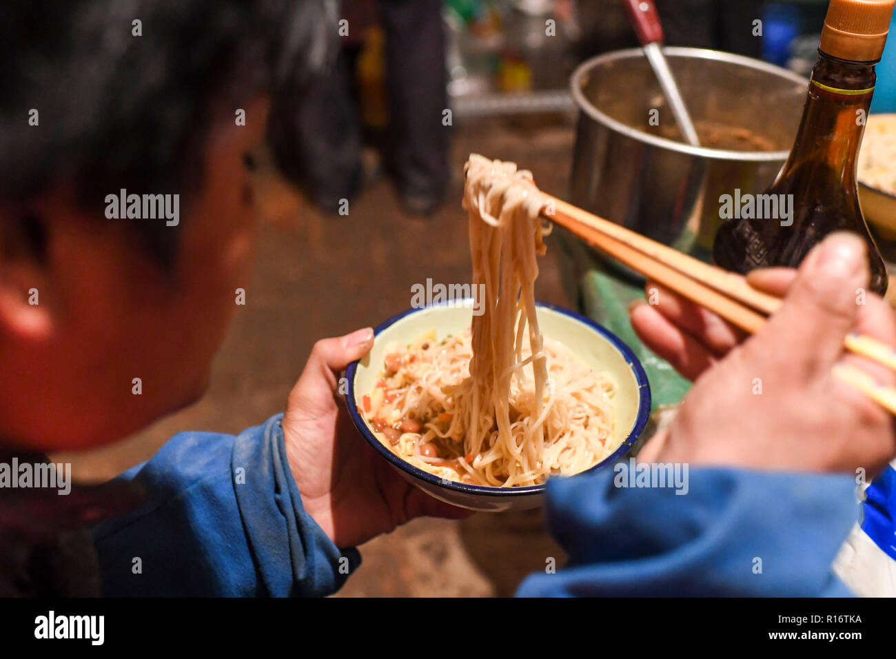 (181110) - - Urumqi, November 10, 2018 (Xinhua) -- chen Xibo hat sein Abendessen im Haus seines Freundes, Dolatbag Stadt Bachu County im Nordwesten Chinas Autonome Region Xinjiang Uygur, Okt. 23, 2018. Chen Xibo, 30, gebürtiger Zhaotong County aus dem Südwesten Chinas Provinz Yunnan, zusammen mit 4 anderen Familienmitgliedern, begann die diesjährige Saison Expedition in die Baumwolle reiche Region zu helfen, die Ernte die Ernte vor zwei Monaten. Ein erfahrener Arbeiter, Chen erwartet mindestens die Hälfte der insgesamt in diesem Jahr das Ergebnis nach 3 Monaten harter Arbeit Baumwolle hier sammeln. Ein Tag beginnt nach einem Schlaf in das Haus eines Freundes, der Ju Stockfoto