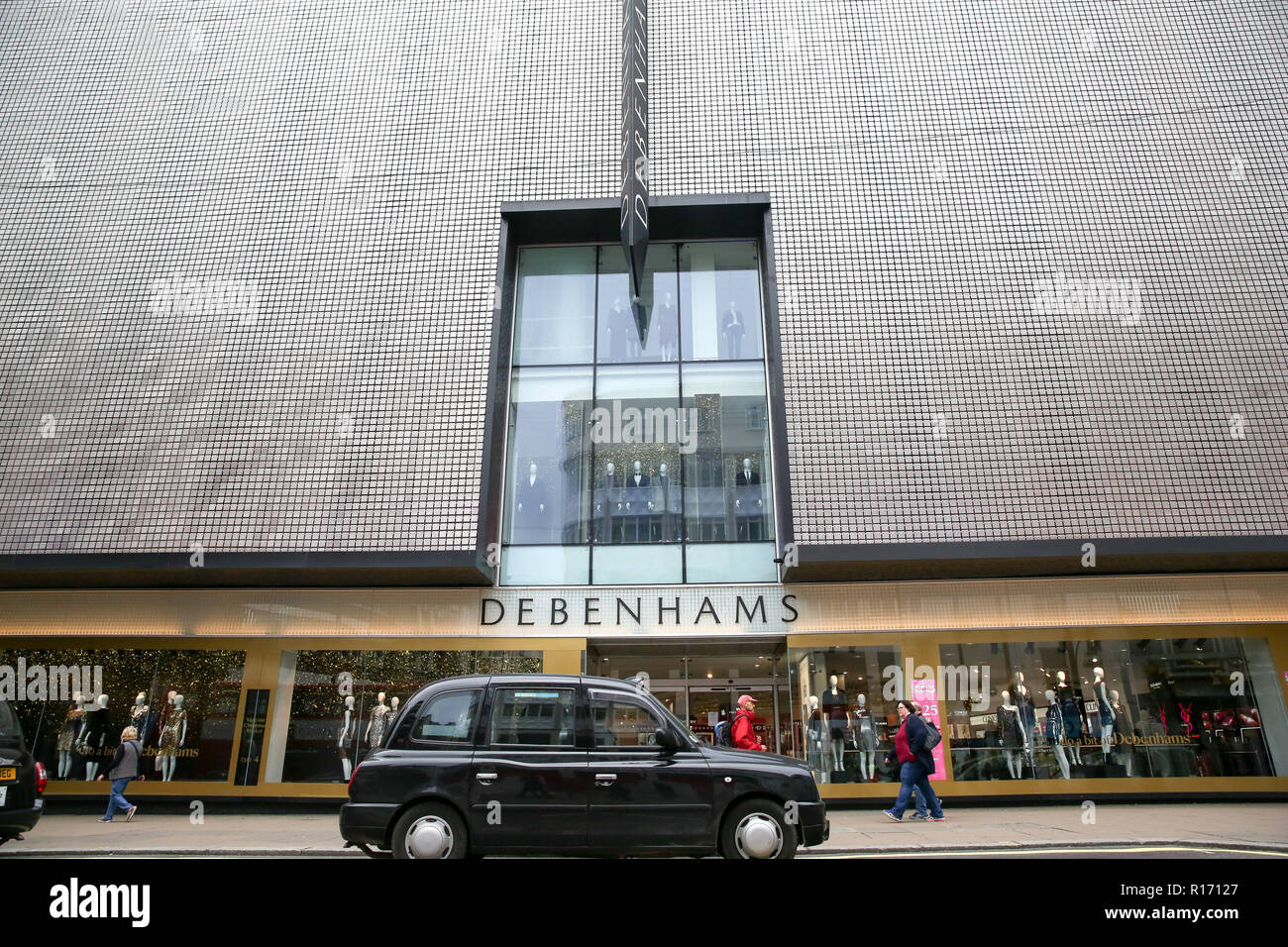 Die schwarzen Londoner Taxis und Käufer außerhalb Debenhams Store auf der Londoner Oxford Street gesehen. Debenhams Pläne bis zu 50 Filialen zu schließen, fast ein Drittel der UK-wide Kette, bis zu 5.000 Arbeitsplätze in Gefahr. Das Kaufhaus stellte eine in der Nähe von £ 500 m jährliche Verlust wie es schreibt den Wert der Marke und die Kosten der unerwünschten shop Leasing und IT-Systeme. Der Einzelhandel Schwierigkeiten als Verbraucher auf Ausgaben und mehr von ihr Einkaufen online tun. Einem Bericht der Wirtschaftsprüfungsgesellschaft PWC hat gesagt, dass über 1.000 Filialen von Britain's Top 500 hohe Straßen in den ersten sechs Monaten verschwunden Stockfoto