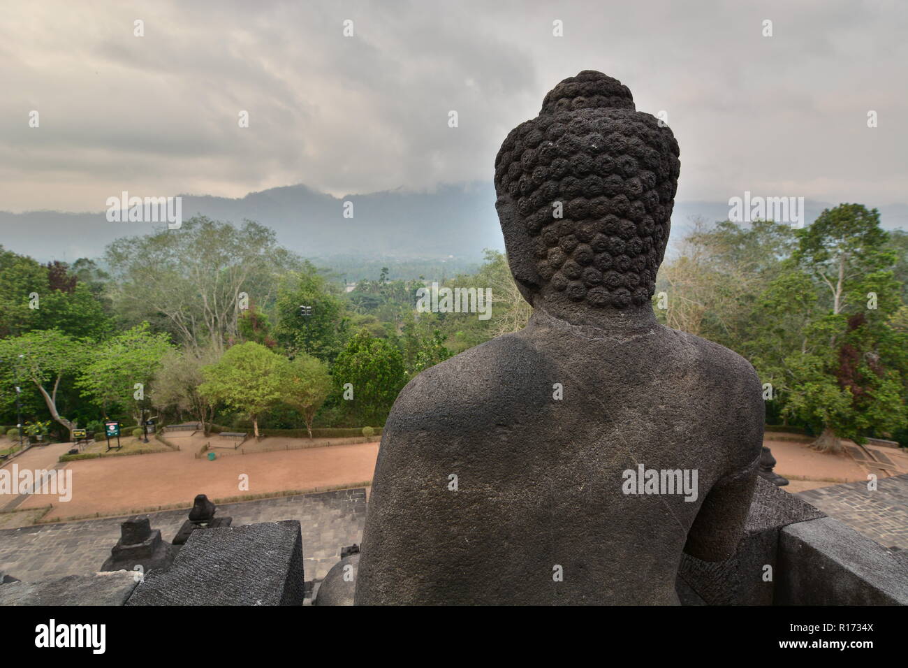 Ein Buddha Statue mit Blick auf die Berge. Candi Borobudur. Magelang. Central Java. Indonesien Stockfoto