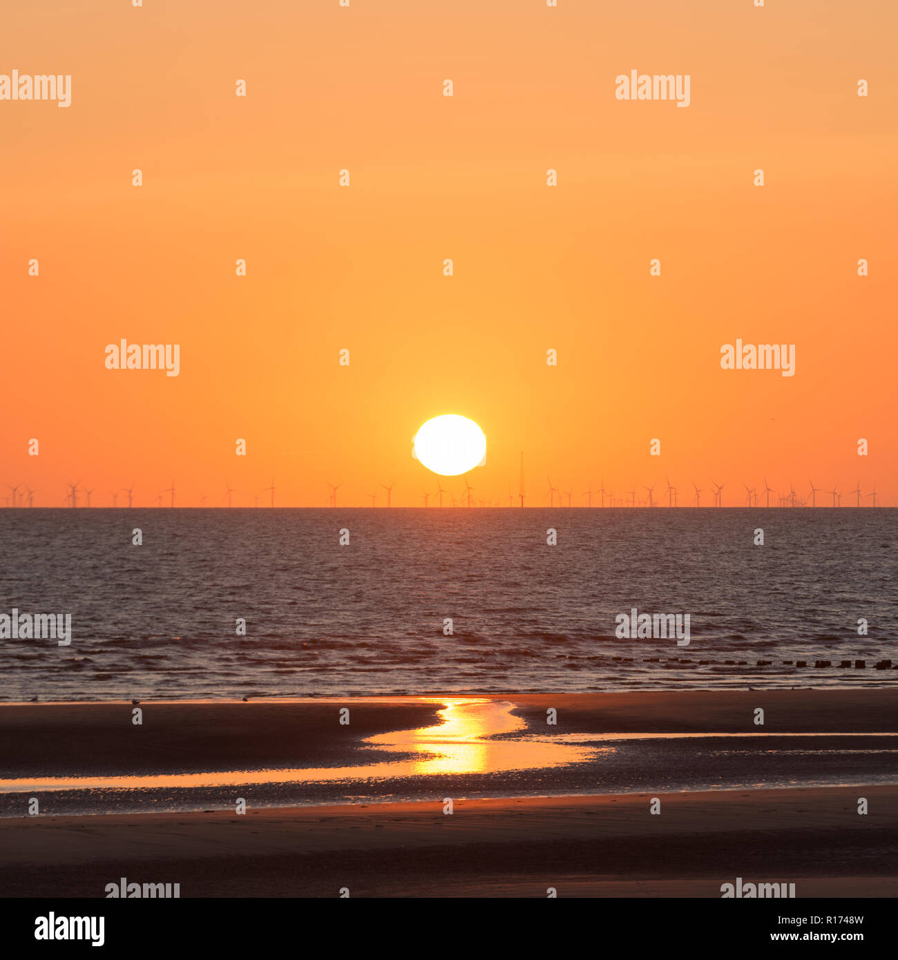 Die untergehende Sonne über dem Meer Stockfoto