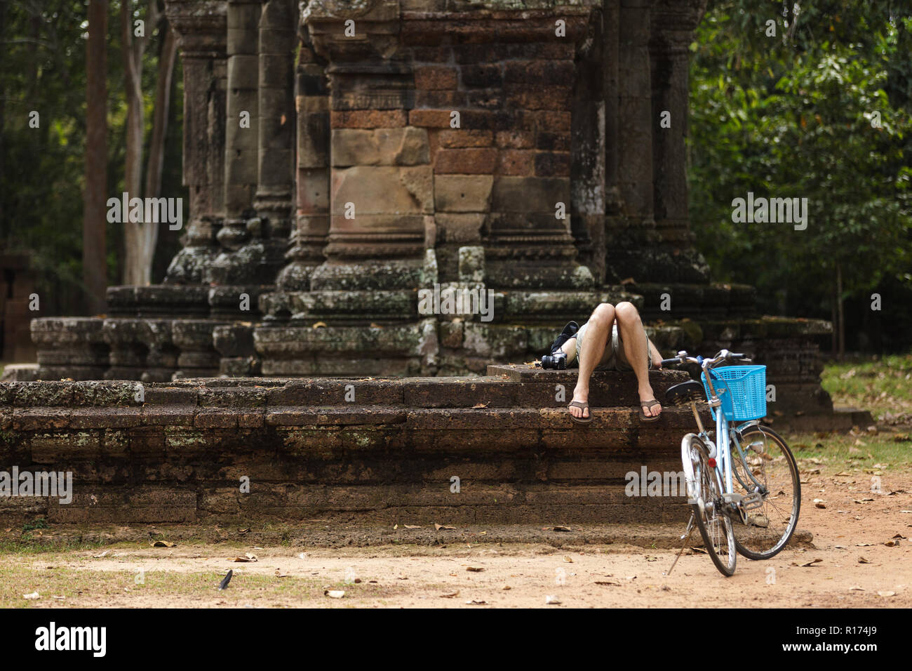 Erschöpft touristischen Anschlag Reiten Fahrrad- und ein Nickerchen auf Tempel Angkor in Kambodscha Stockfoto